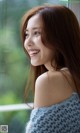 A woman with long brown hair smiles at the camera.